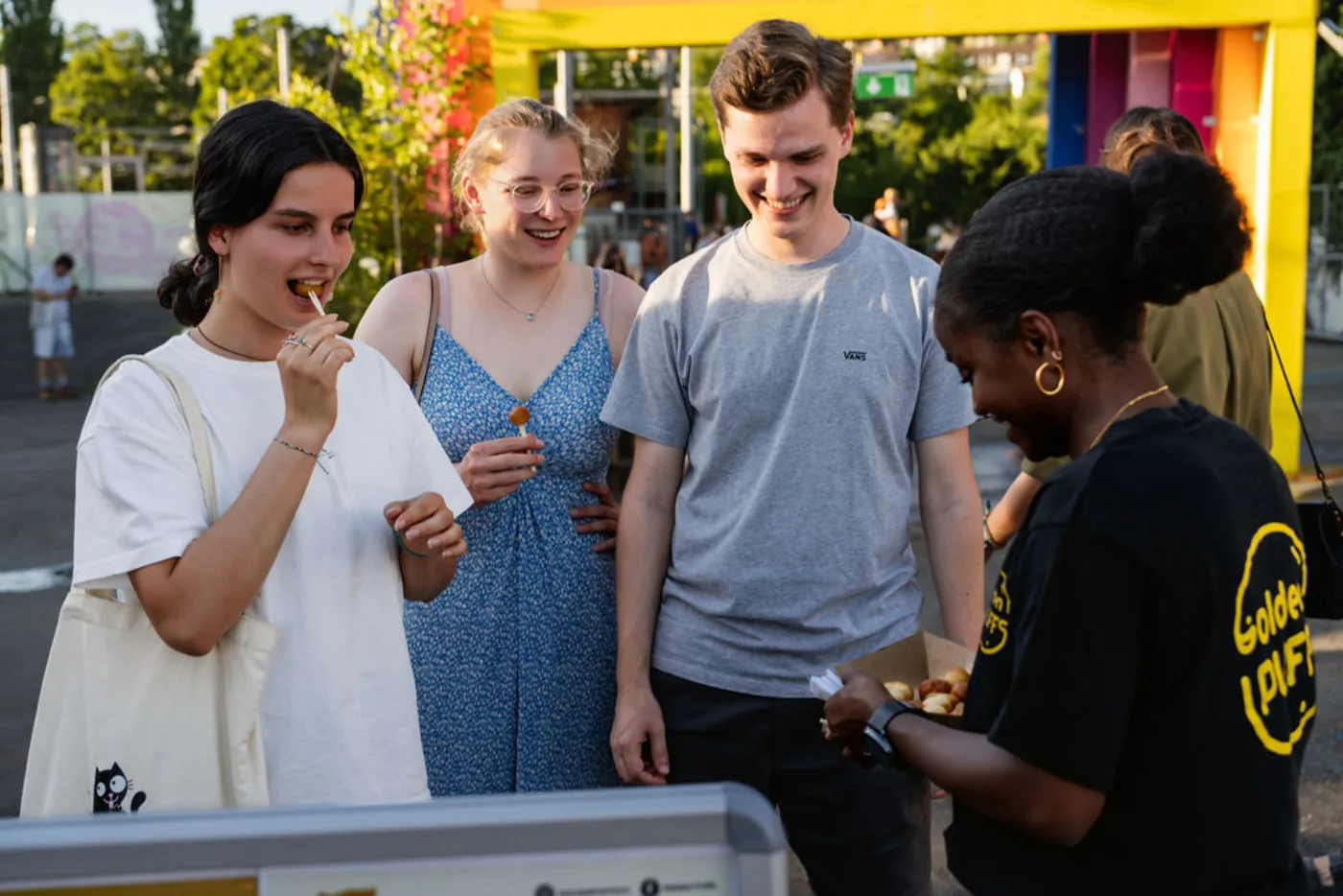 The Golden Puffs team at the stand during a festival, with smiling customers.